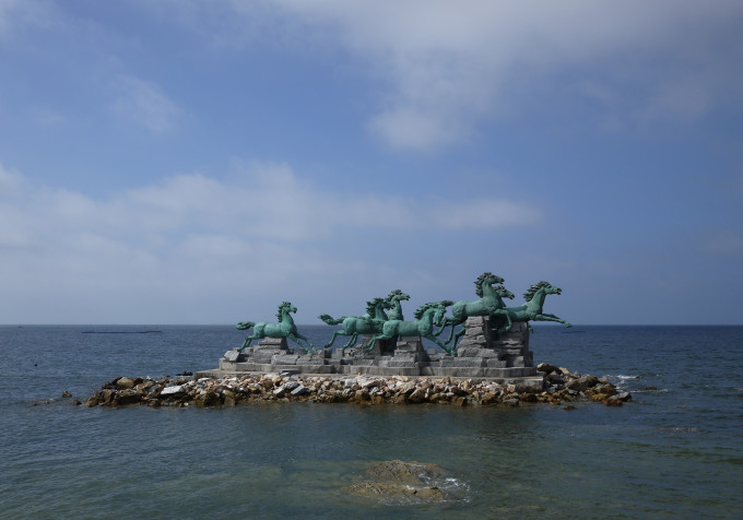 烟台养马岛,也即是养马岛旅游度假区,地处烟台东30公里,牟平区城北9公里的黄海之中,总面积10平方公里,岛上风光秀丽,气候宜人,冬无严寒,夏无酷暑,是休闲度假的理想境地,现在已被建设成为省级旅游度假区。养马岛历史悠久,相传秦始皇东巡时在此饲养御马,并封为皇家养马岛,养马岛因此得名。岛上丘陵起伏,草木葱茏,山光海色,秀丽如画,海岛呈东北西南走向,地势南缓北峭,岛前海面宽阔,风平浪静,岛后群礁嶙峋,惊涛拍岸;东端碧水金沙,是优良浴场。西端水深浪小,天然良港。岛四周盛产海参、扇贝、鲍鱼、对虾、牡蛎、天鹅蛋等海